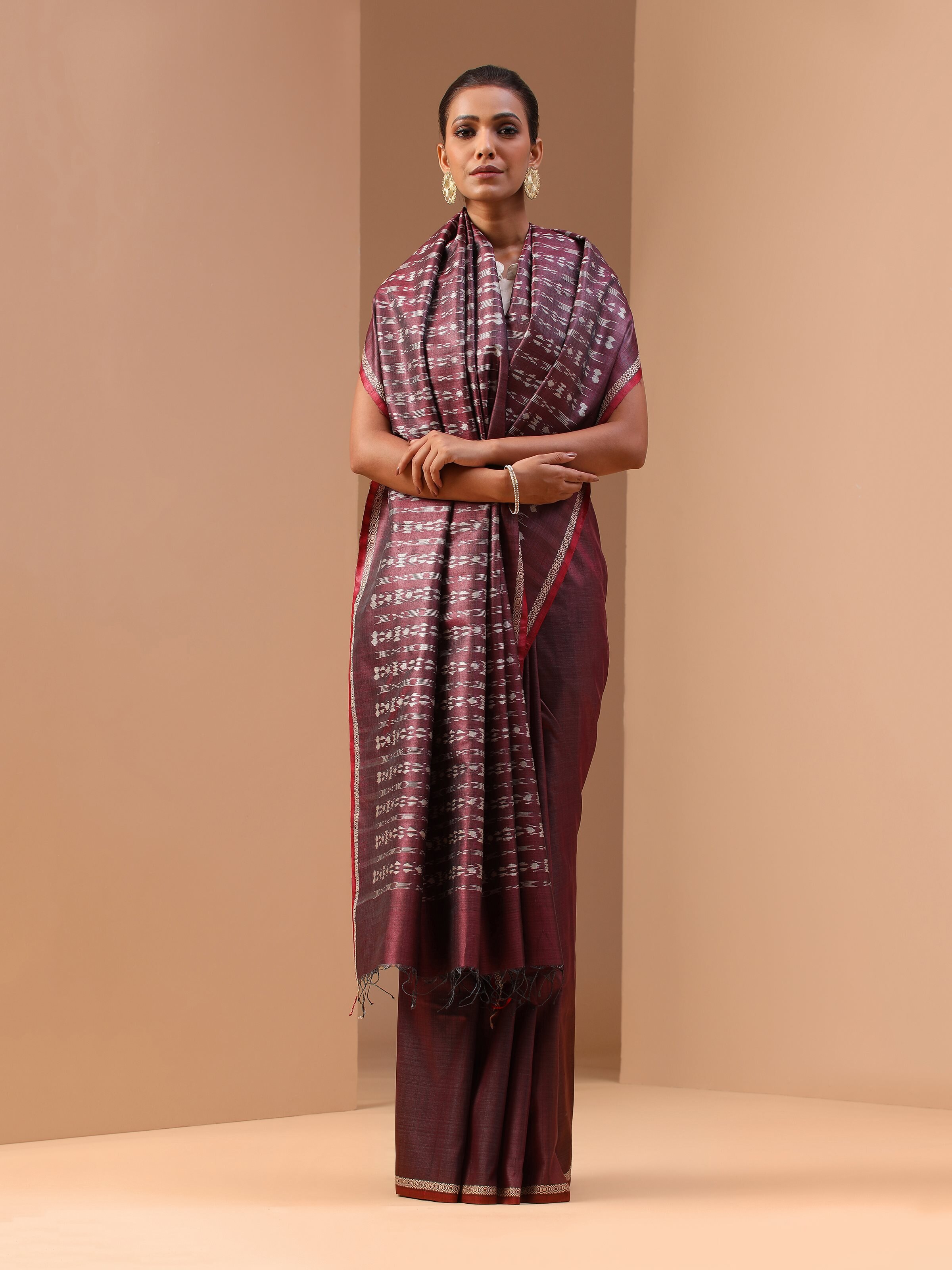Lifestyle shot of purple tussar silk Odisha Ikat saree draped elegantly to highlight silk sheen.