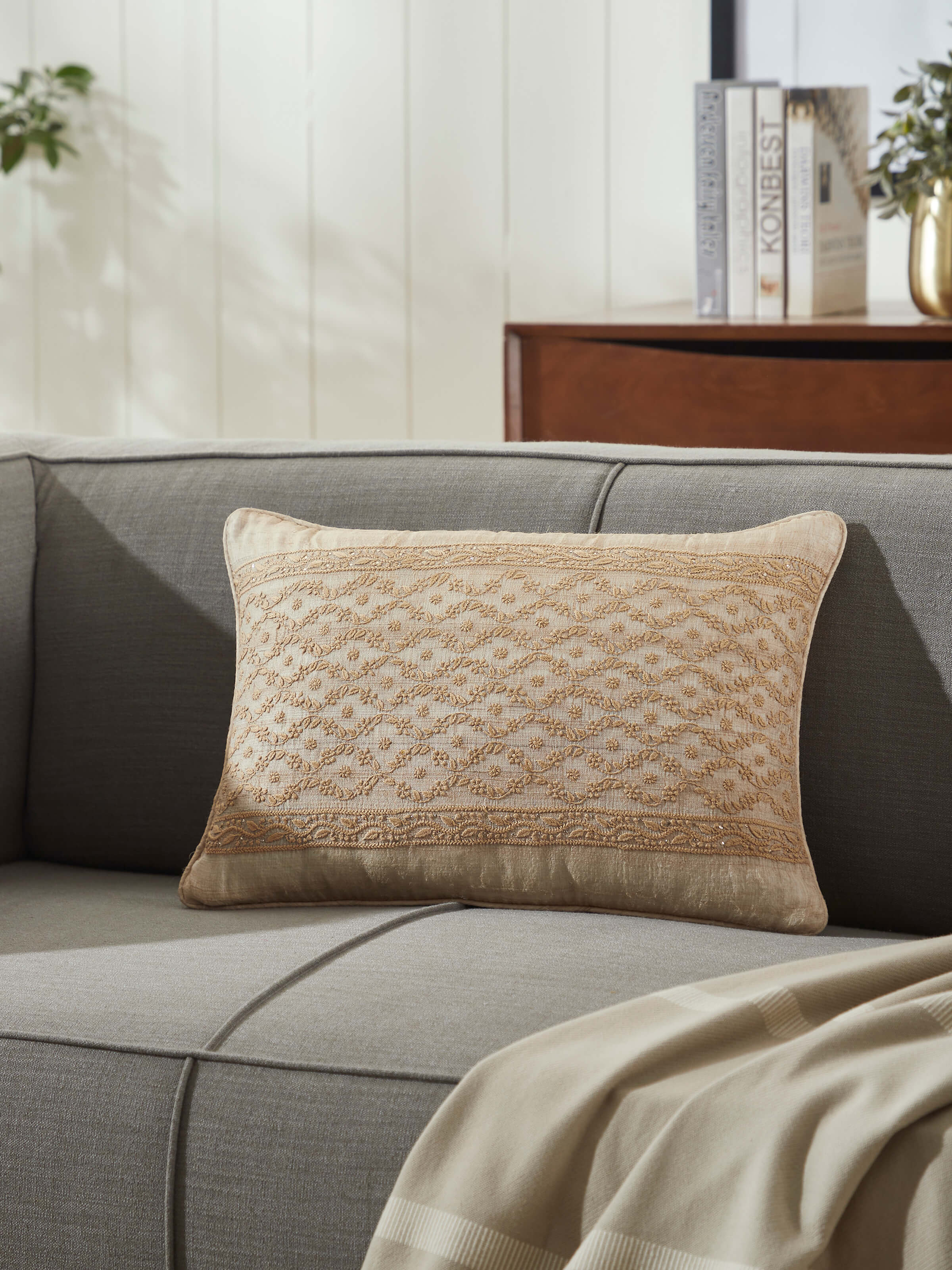 Sofa setup featuring hand-embroidered cushion in soft beige Tussar silk.