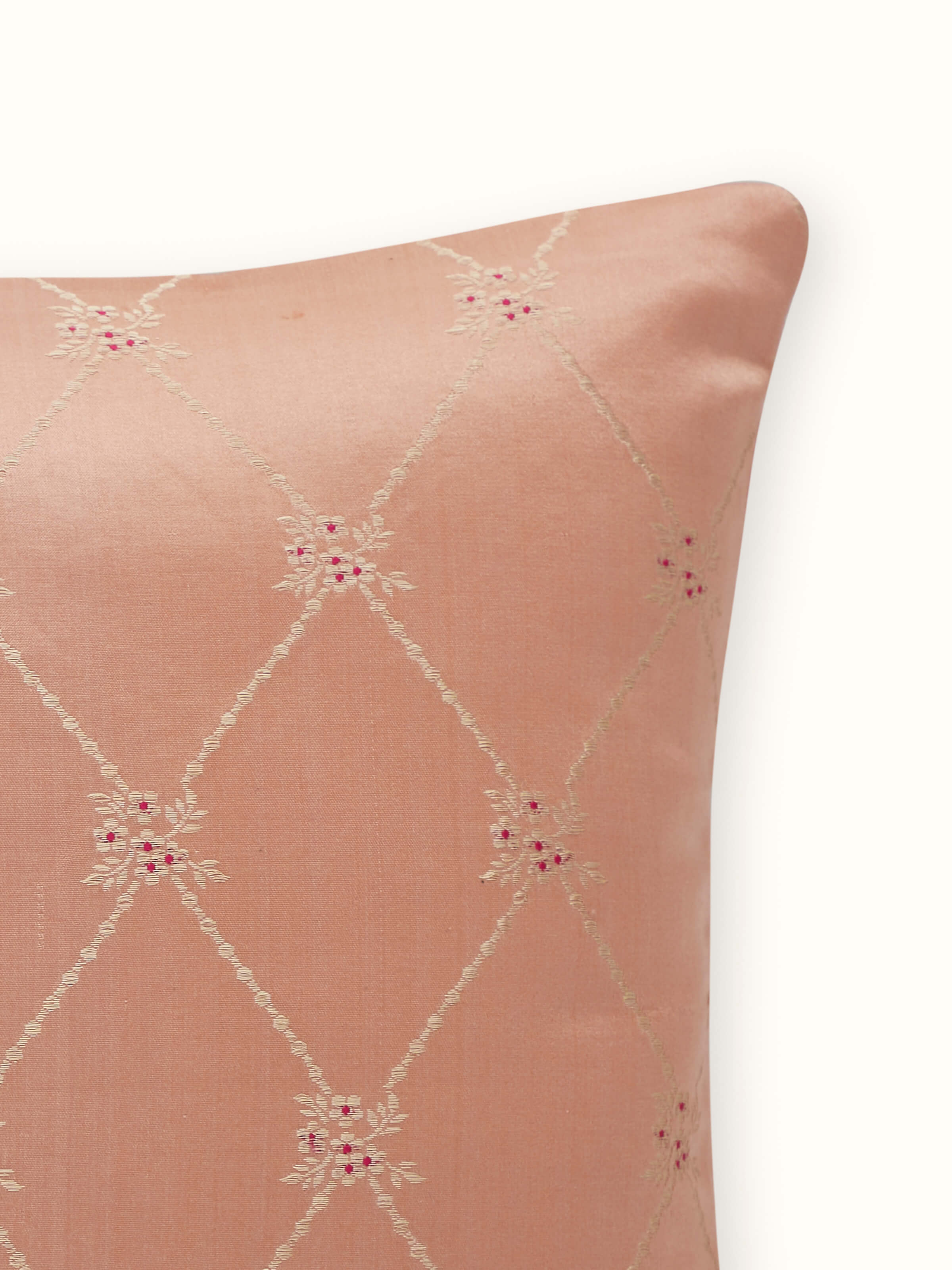 Close-up showing weave and sheen of handloom Banarasi silk in peach cushion cover.