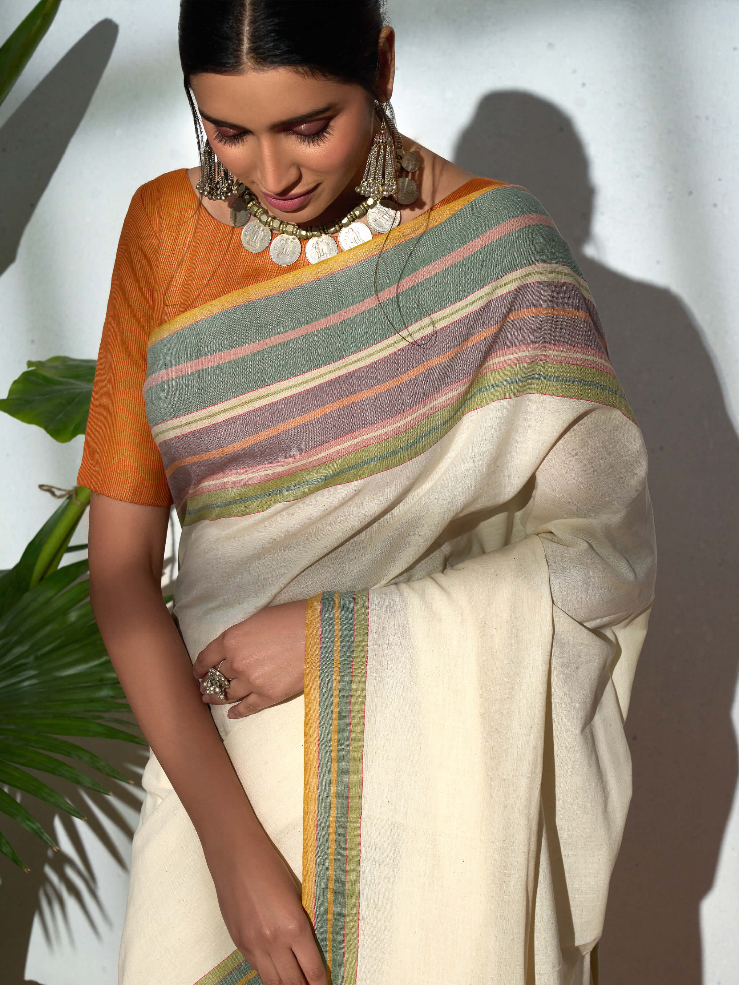 Angled view of cream cotton hand-spun striped saree highlighting stripe pattern