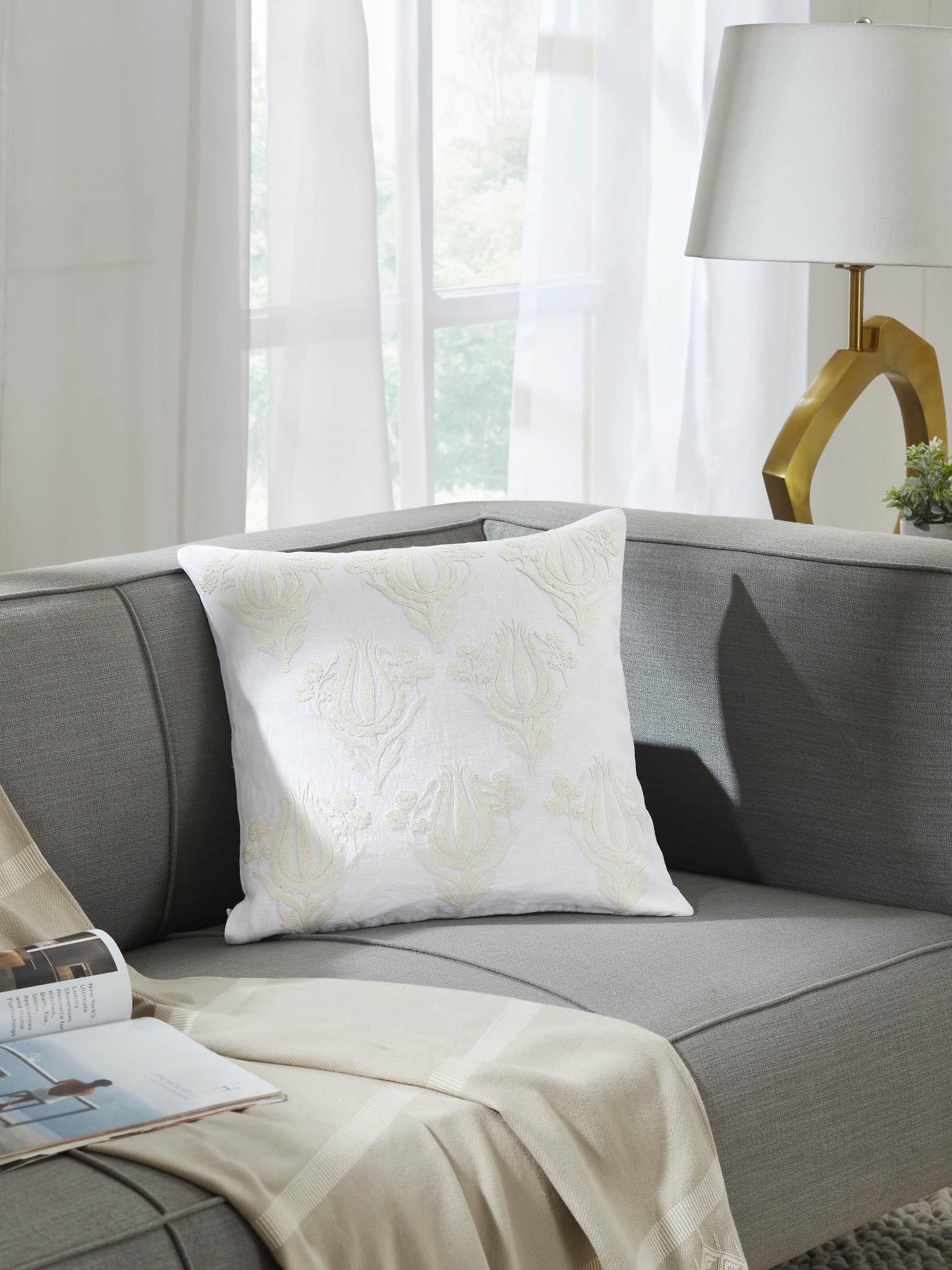 Lifestyle image of embroidered cushion cover styled on a sofa, reflecting artisanal Kashmiri craft.