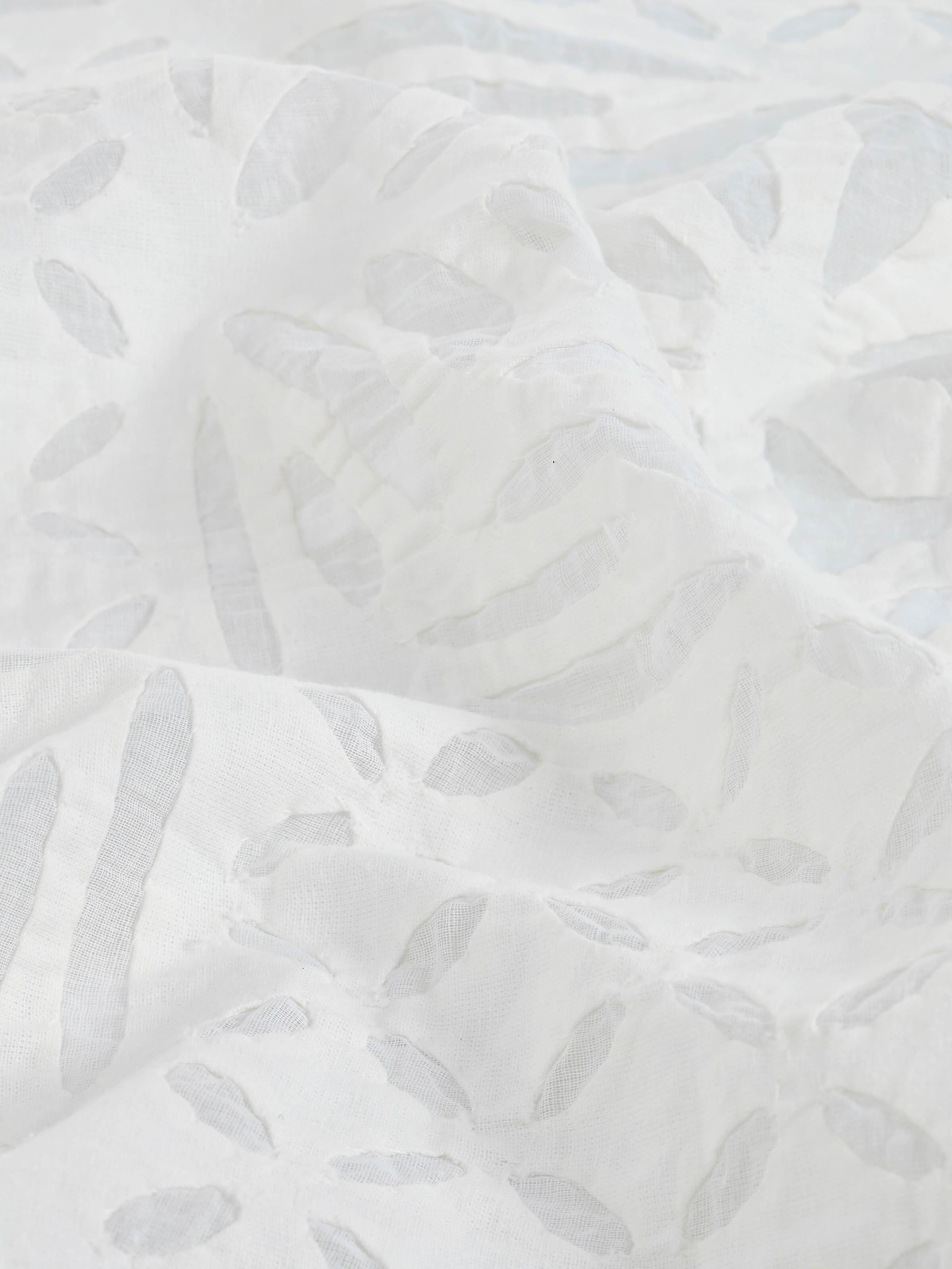 Detail shot capturing the hand appliqué craftsmanship and texture