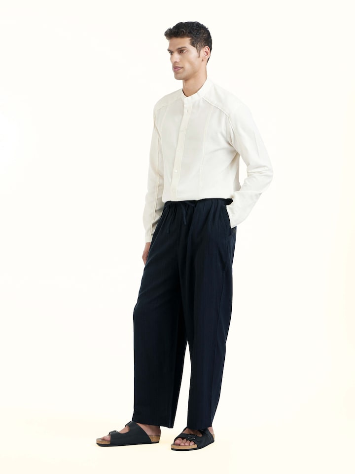Side view of black silk handloom straight pants showing straight cut and smooth drape
