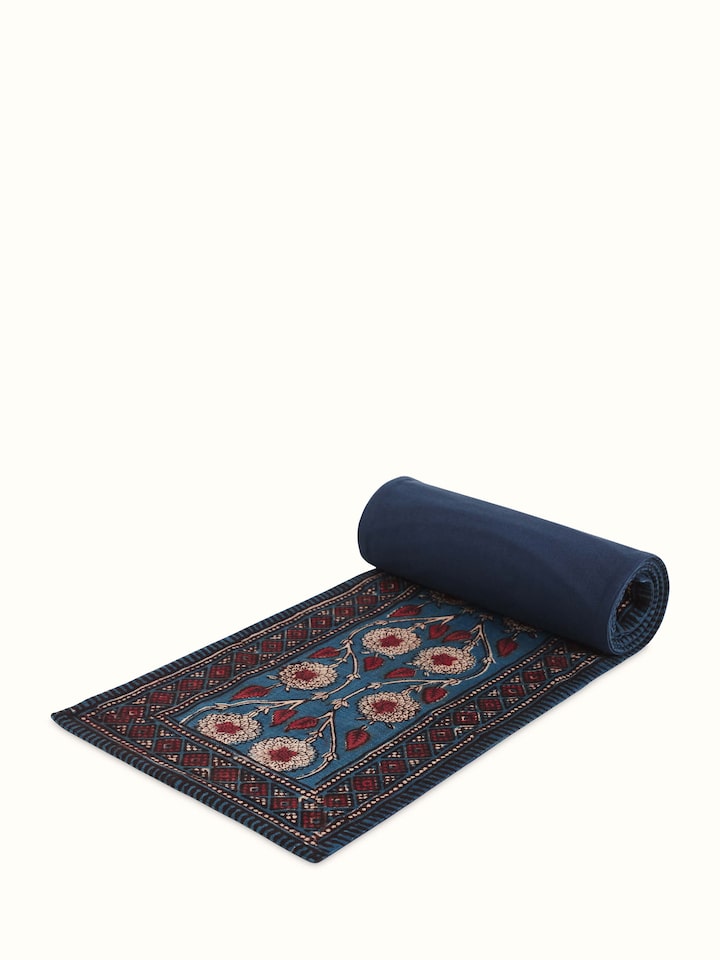 Close-up of indigo cotton Dabu hand block printed table runner rolled to show the block print border