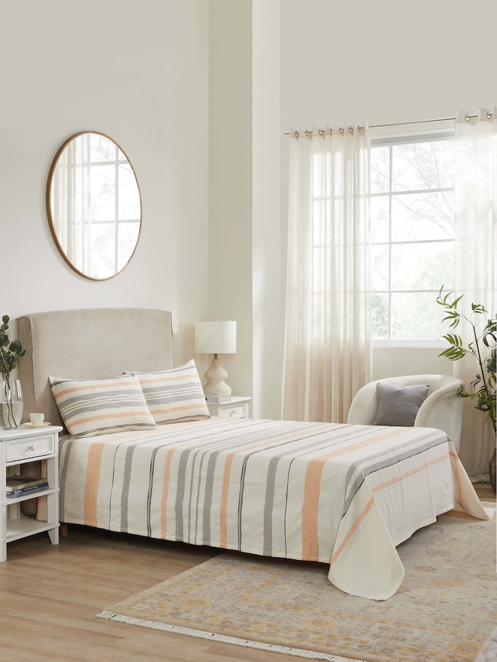 Lifestyle view of Neerja grey stripe cotton bedspread set styled on a wooden queen bed