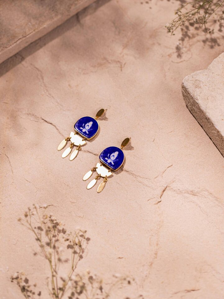 Side view of blue pottery drop earrings showcasing their intricate design