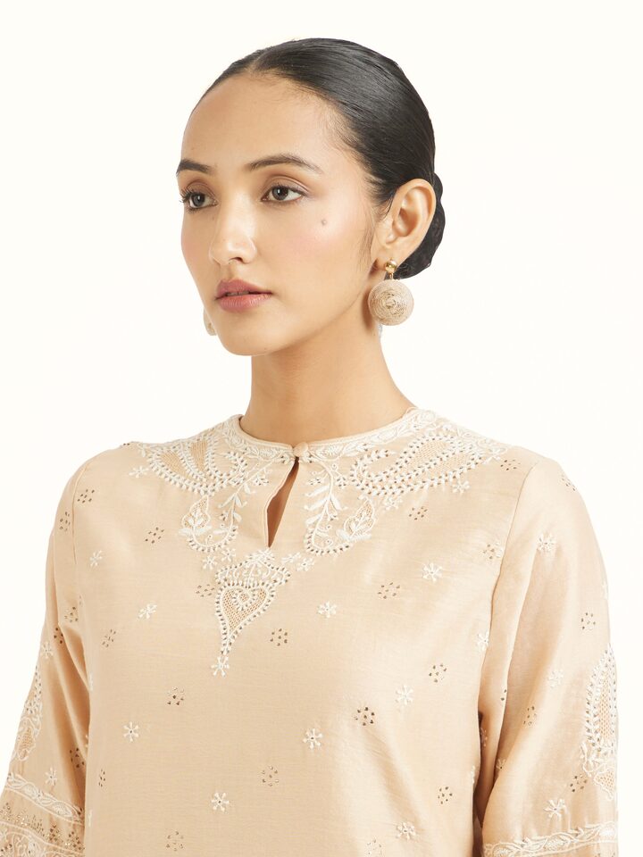 Angled view of beige silk chikankari kurta highlighting embroidery patterns