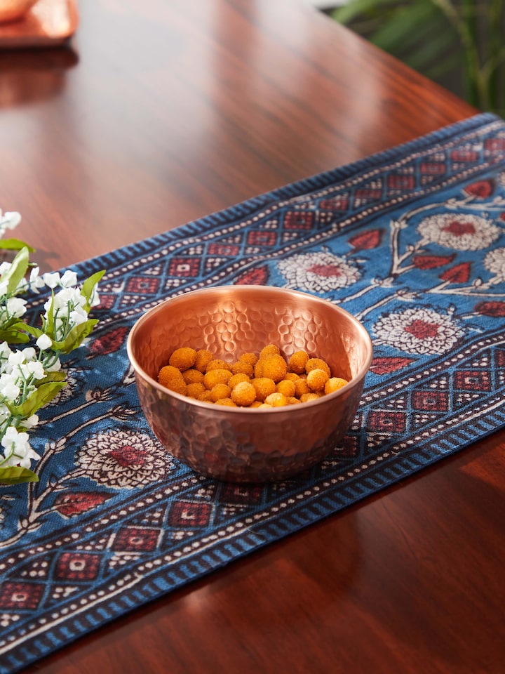 Side view of Copper Fruit Bowl highlighting its reflective surface and modern, sleek shape.