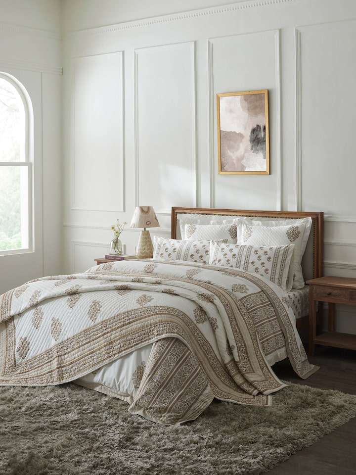 Saha beige buta Sanganeri hand block printed cotton double quilt laid on bed