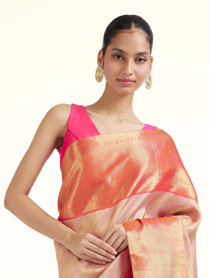 Angled view of light pink silk Kancheepuram saree highlighting traditional weave and soft sheen