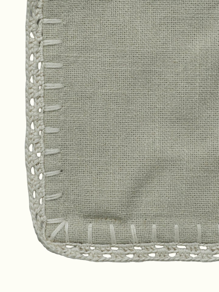 Detail view of Nityam Beige Cotton Slub Crochet Coasters Set Of 6 highlighting the fabric texture and embroidery detail, from a different angle