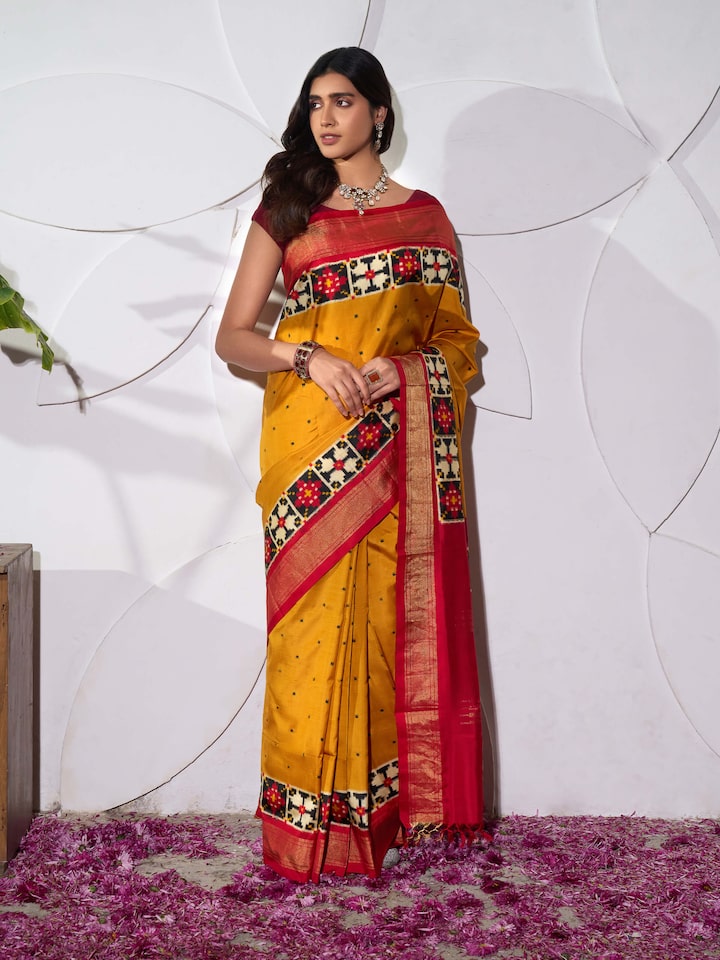 Side view of yellow silk Pochampally double ikat saree highlighting silk drape