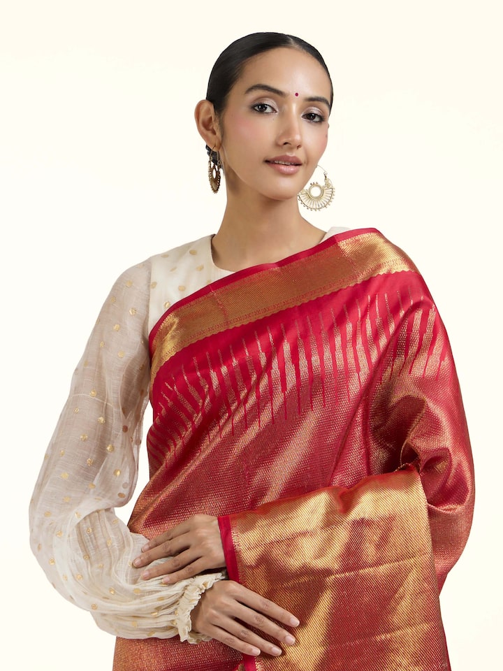 Angled view of red silk Kancheepuram saree highlighting traditional weave and sheen