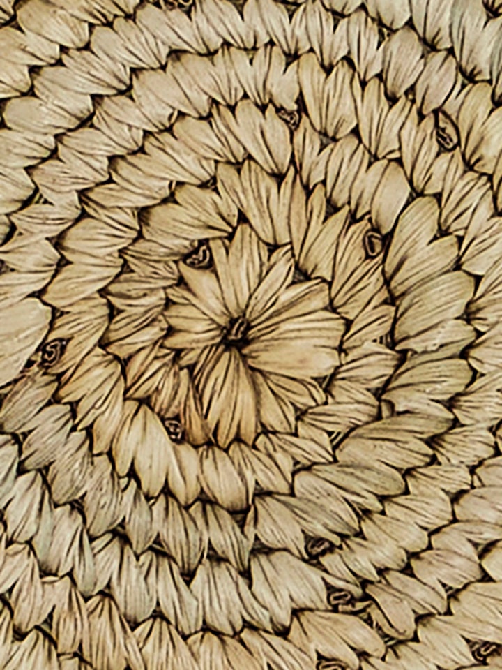 Close-up of Amodini light green round Sabai coasters showcasing spiral weave and natural colour variations.