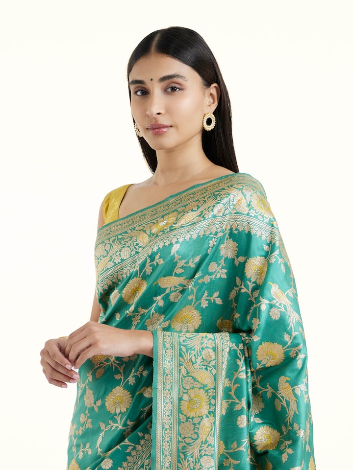 Angled view of sea blue mulberry katan silk Banarasi saree highlighting traditional weave and sheen