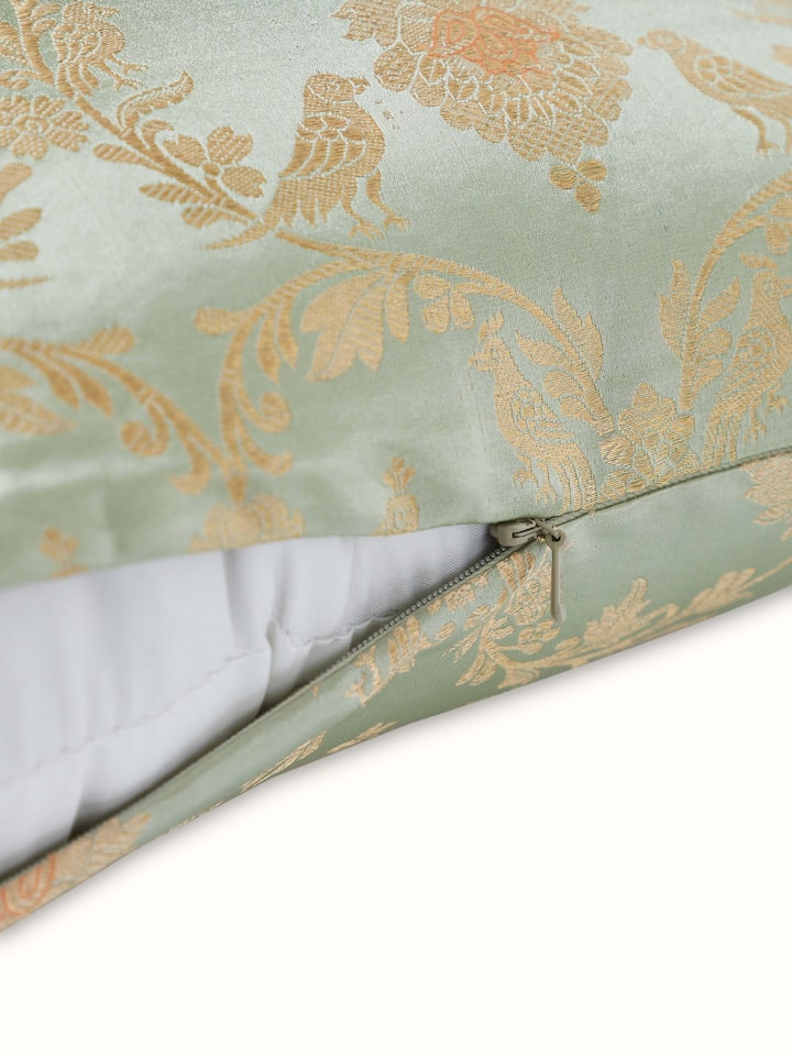 Angled view: Angled view highlighting rich Banarasi weave and elegant sheen of the green silk cushion.