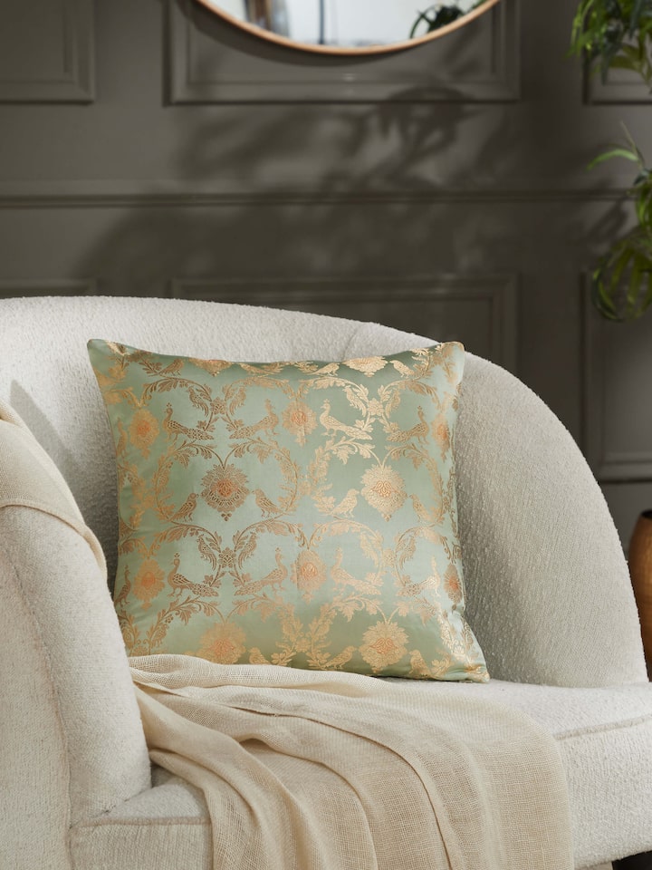 Lifestyle image of Awadh silk cushion cover on a couch, exuding luxury and craftsmanship.