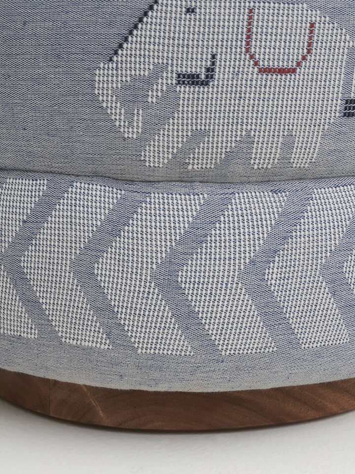 Angled view of the pouffe, capturing the overall design and the craftsmanship of the Sheesham wood base