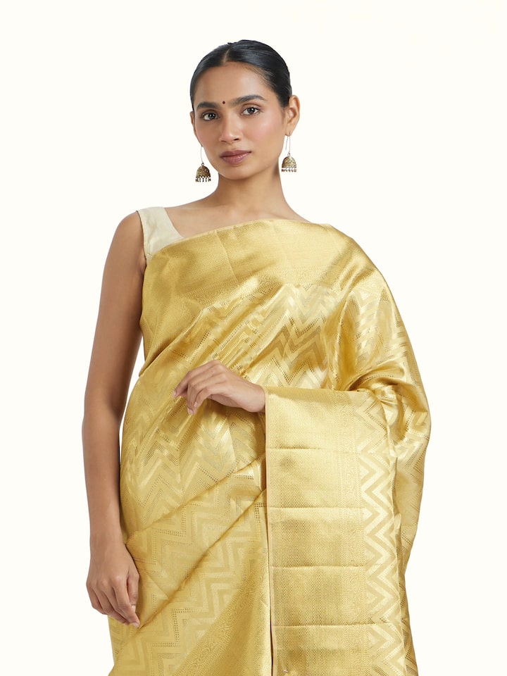 Angled view of Gold Kancheepuram Silk Zari Saree revealing the depth of its color and intricate pattern