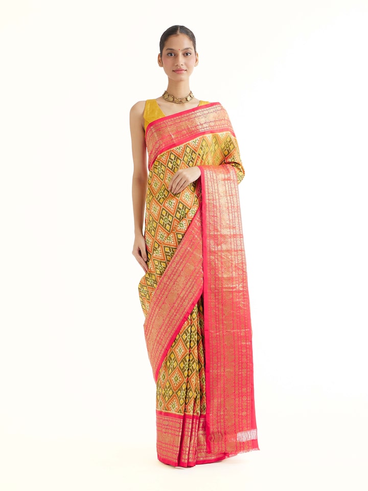 Front view of green silk ikat saree with bold woven motifs