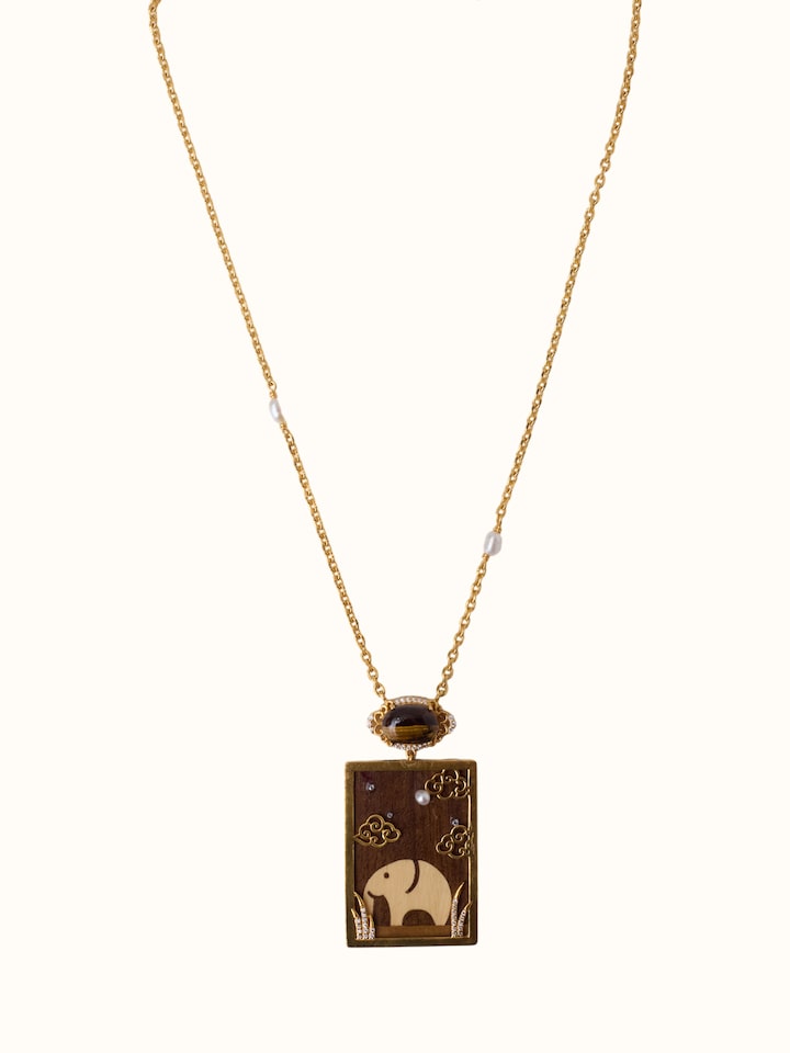 front view of rosewood inlaid silver pendant and chain with intricate craftsmanship
