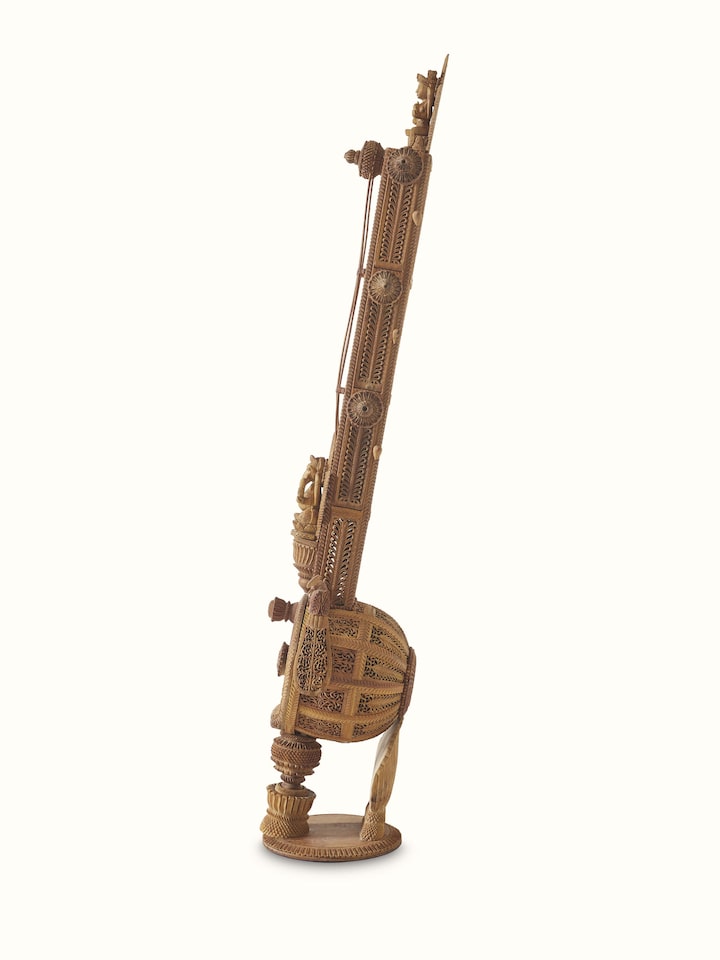 Carved sandalwood veena sculpture with focus on the fine carvings and intricate detailing.