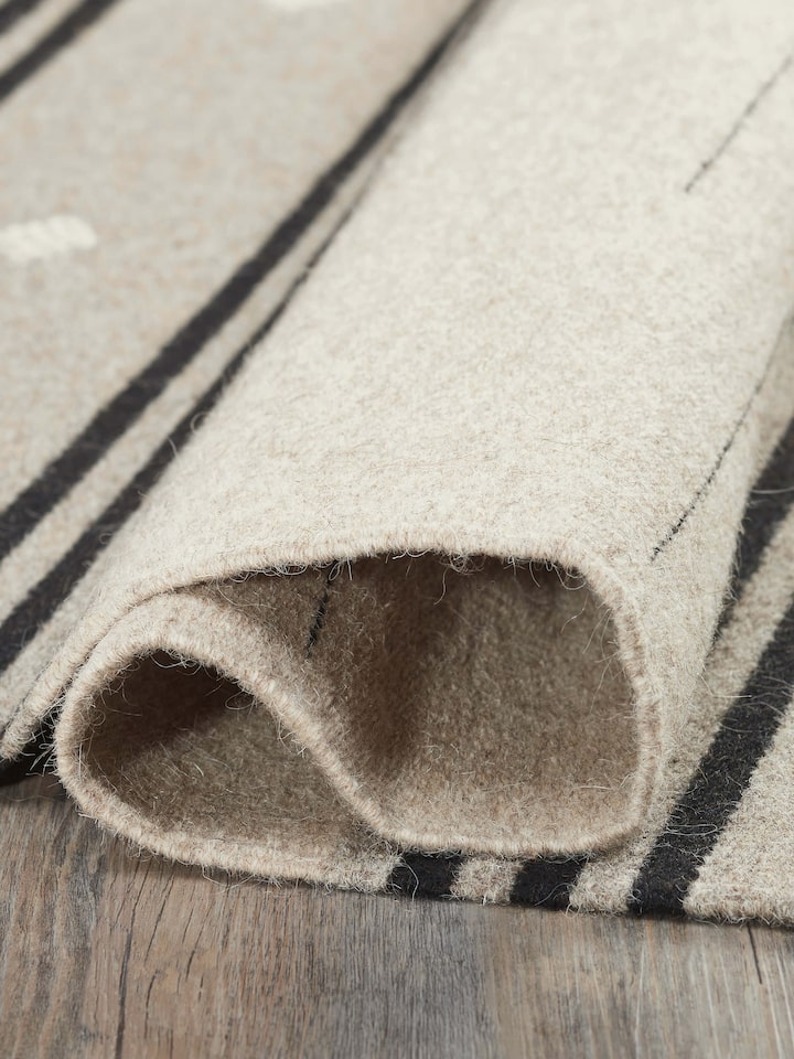 Close-up of Nomad stripes beige black Jawaja wool & cotton handloom dhurrie (3x5 ft) highlighting the fabric texture and stripe pattern
