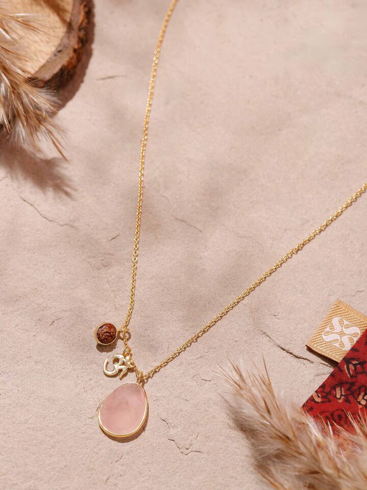 Side view of Rudraksha, Om Charm & Rose Quartz Necklace displaying rose quartz beads and intricate gold finish