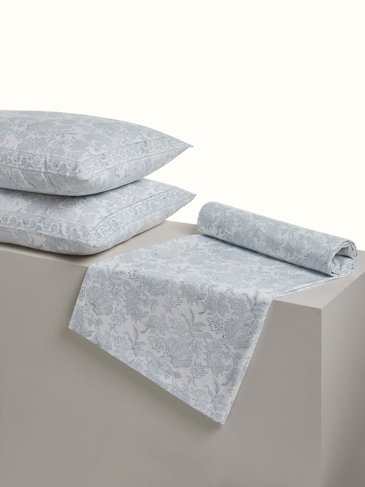 Angled view: Angled view of Kairavam blue cotton bedsheet highlighting block printed floral patterns