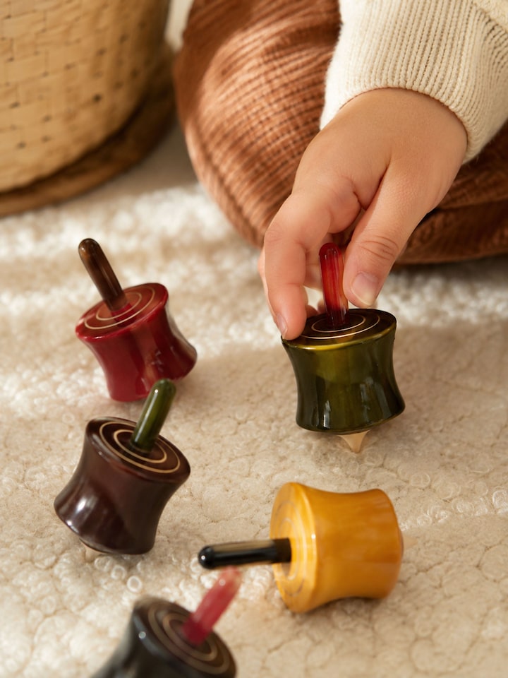 Left-side view of the Channapatna Ivory Wood Cylinder Spinning Toys (6 Pcs)