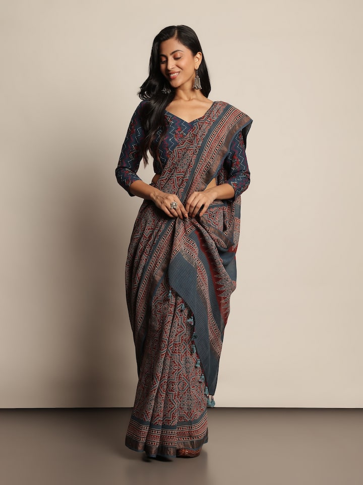 Angled view of blue Maheshwari Ajrakh block printed saree showing print details and fabric texture.