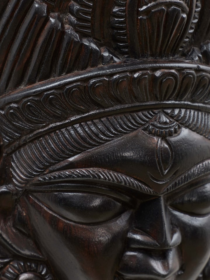 Angled view of Kushmandi goddess wall mask showing sculpted details
