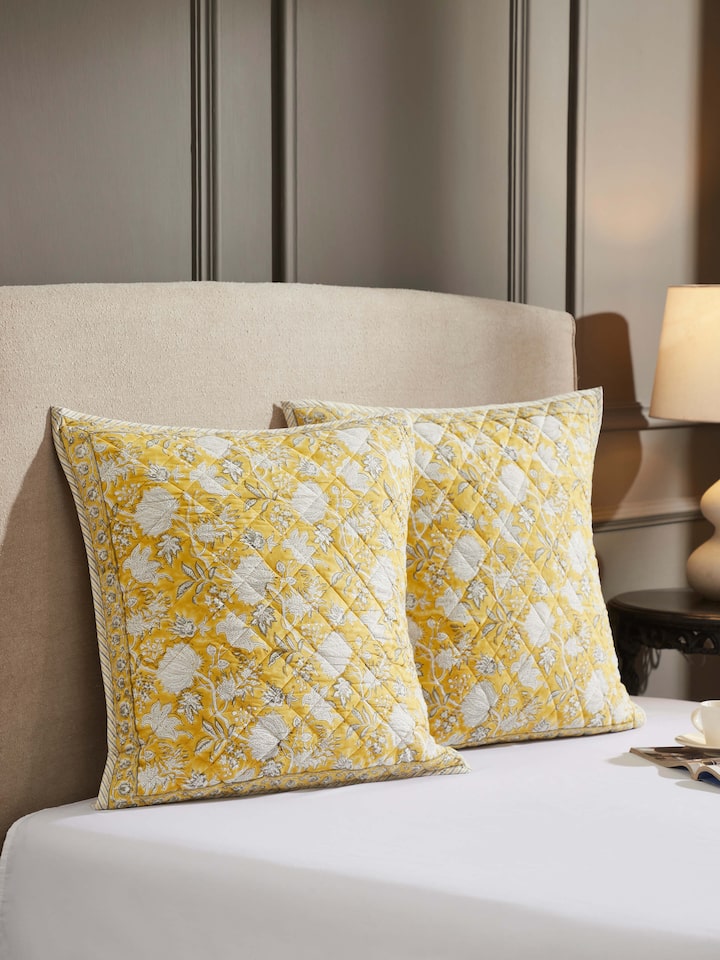 Lifestyle view of floral yellow Sanganeri euro shams adding charm to bedroom setup.