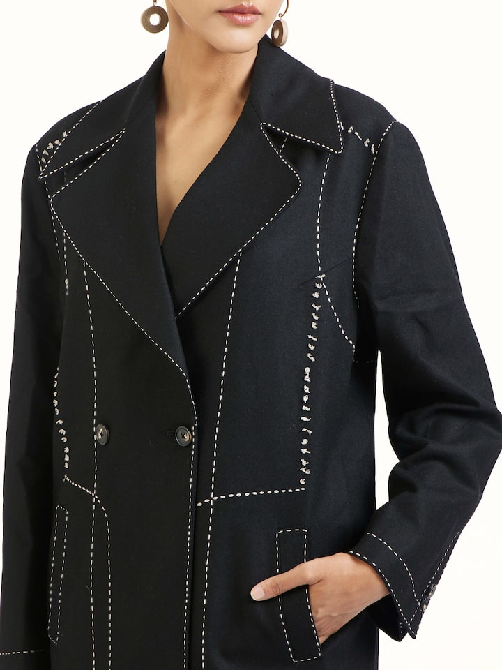 Detail view of black wool kantha jacket showing embroidery texture and fabric
