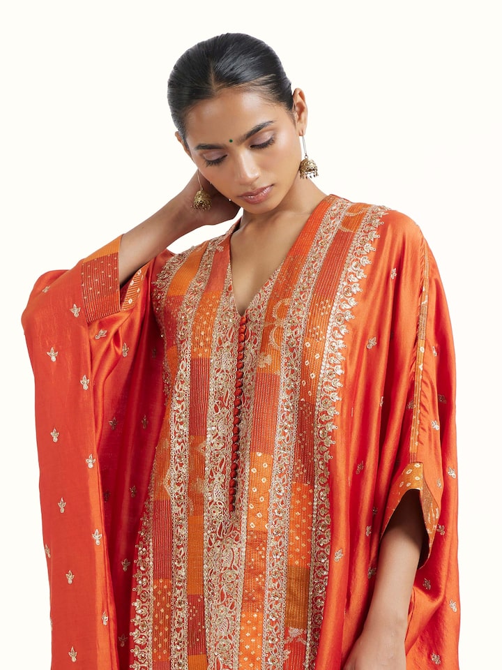 Angled view of rust silk hand embroidery co-ord set highlighting embroidery