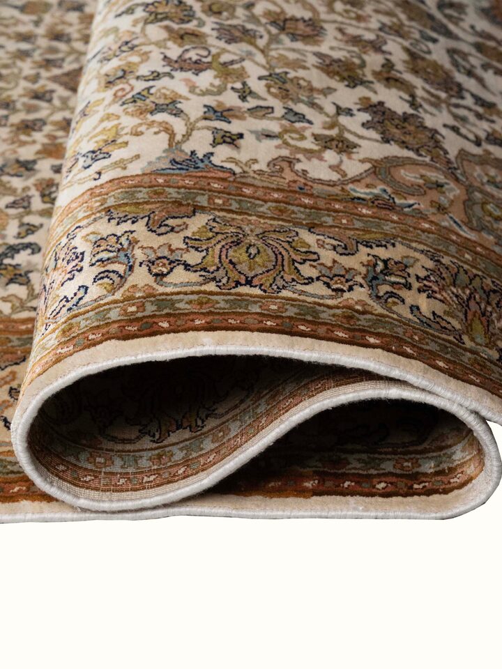 Detail view of Traditional Persian Ivory Kashan Kashmir Silk Hand-Knotted Carpet highlighting the intricate pattern and pile texture, from a differ...