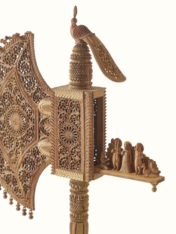 Angled view of Bilara carved sandalwood jaali fan sculpture emphasizing craftsmanship