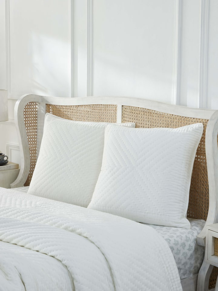 Lifestyle image showcasing Kalpanama Ivory Buti Cotton Euro Shams styled on a bed