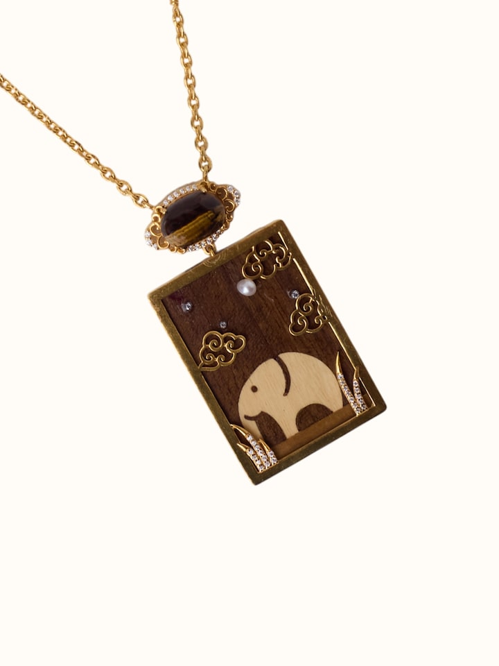 detail view of rosewood inlaid silver pendant and chain design