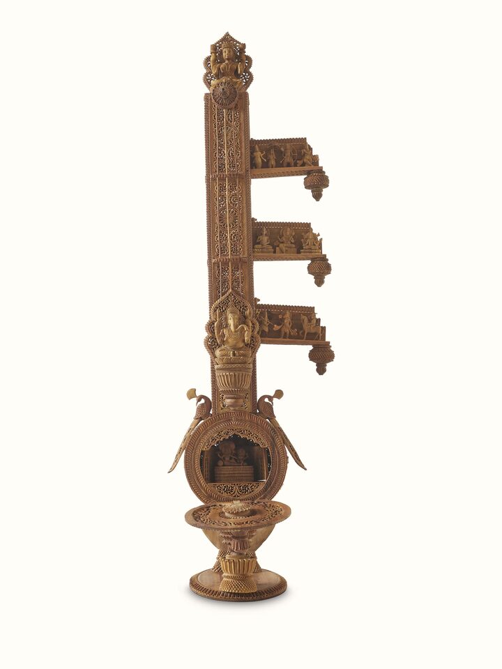 Carved sandalwood veena sculpture in a display setting, emphasizing its elegant and traditional design.