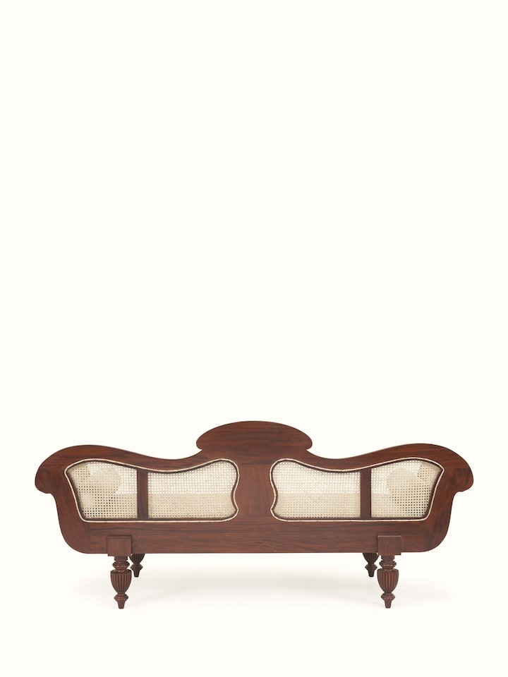 Back view of upholstered Mahogany wood and cane sofa revealing wooden structure and cane backrest