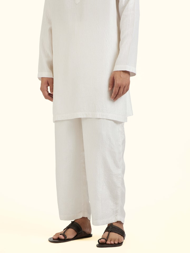 Angled view of white straight quilted tulip pants highlighting structure and fit