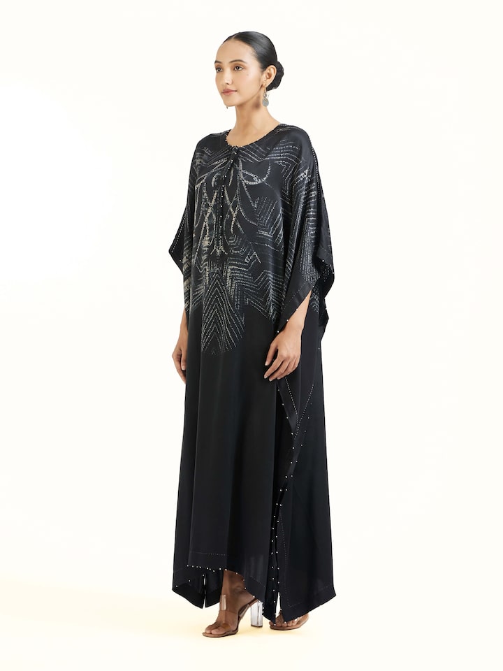 Side view of black satin shibori kaftan showcasing relaxed silhouette