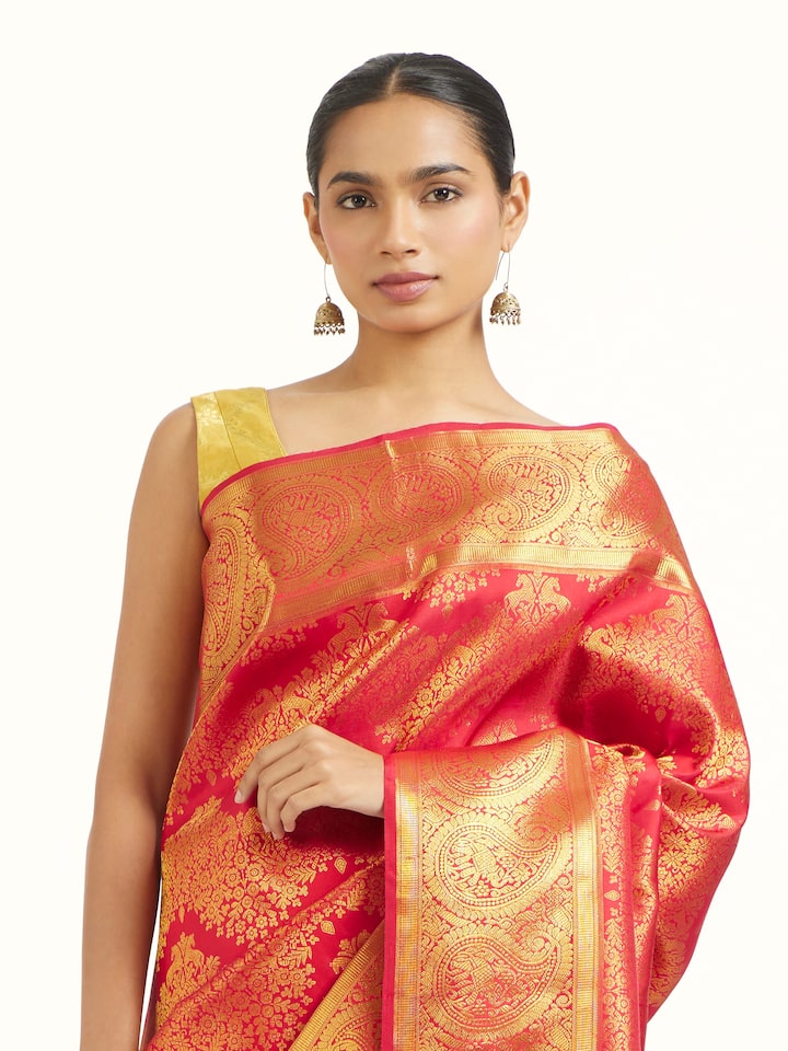 Angled view of red silk Kancheepuram saree highlighting traditional weave and sheen