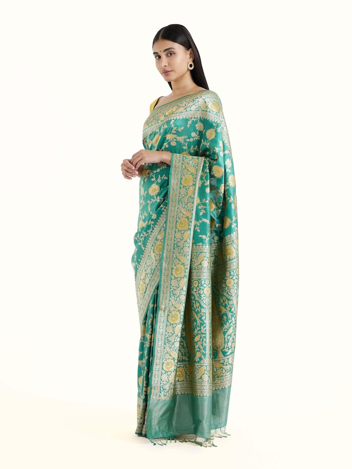 Side view of sea blue mulberry katan silk Banarasi saree with graceful drape and contrast border
