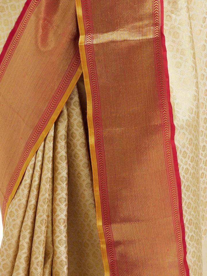 Close-up angled view of peach silk Kancheepuram saree showcasing border and pallu design