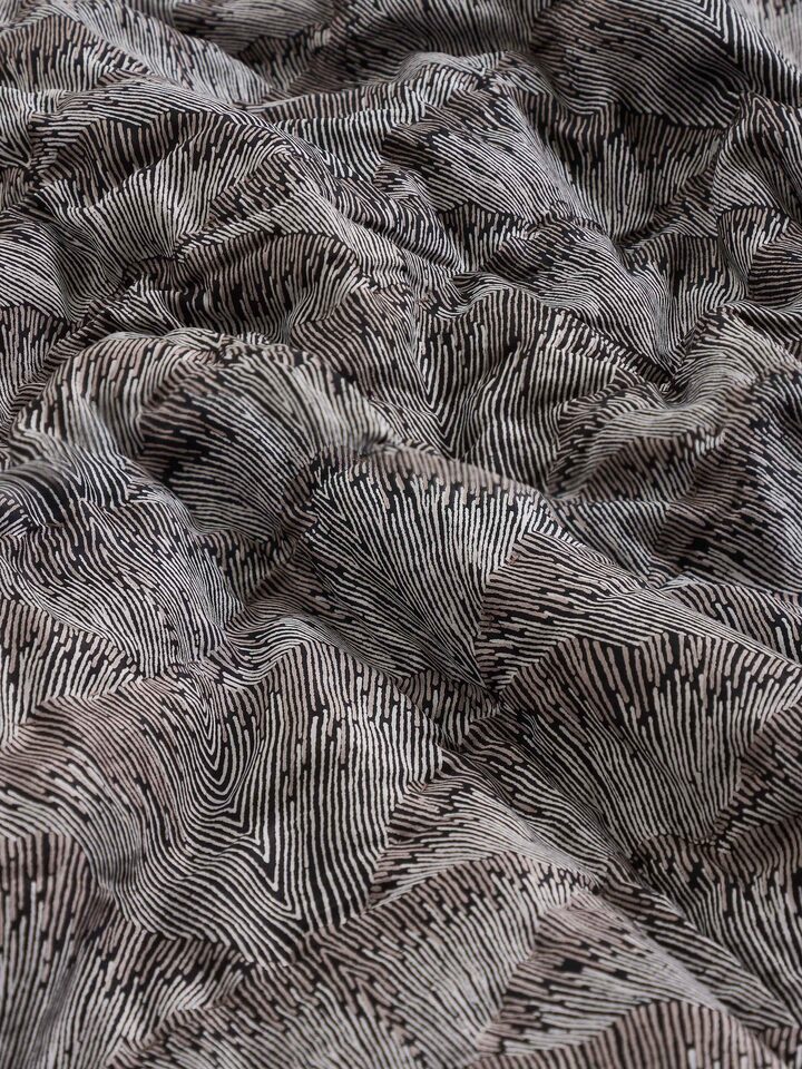 Detail shot of floral block print and textured finish on Parvat brown silk quilt.
