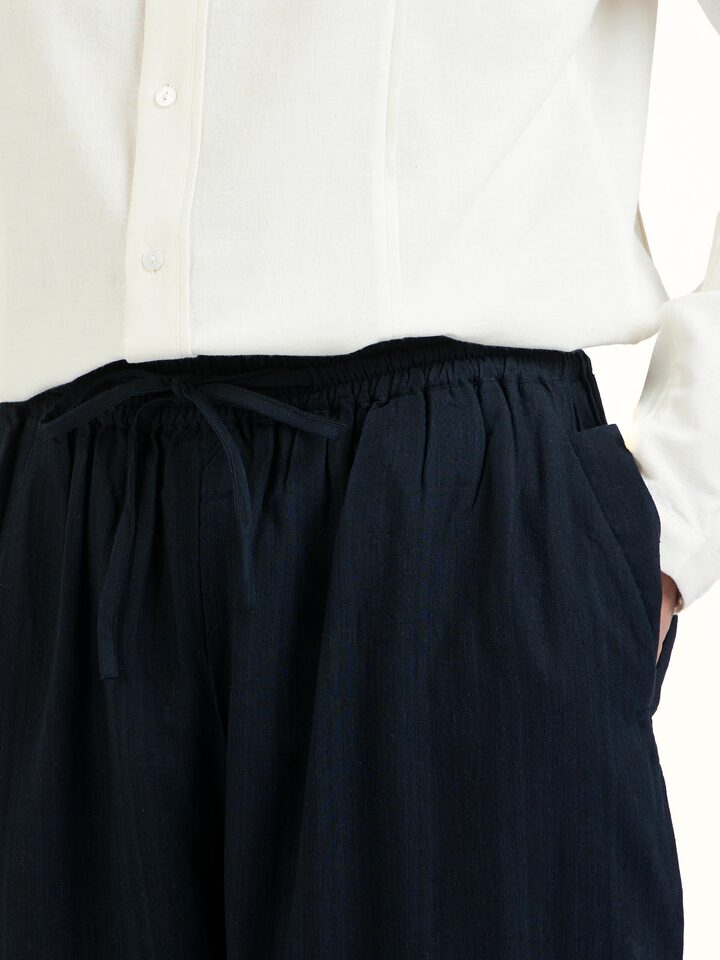 Detail view of black silk handloom straight pants showing weave texture and stitching
