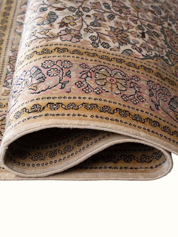 Detail view of Traditional Persian Ivory Kashan Kashmir Silk Hand-Knotted Carpet highlighting the intricate pattern and pile texture, from a differ...