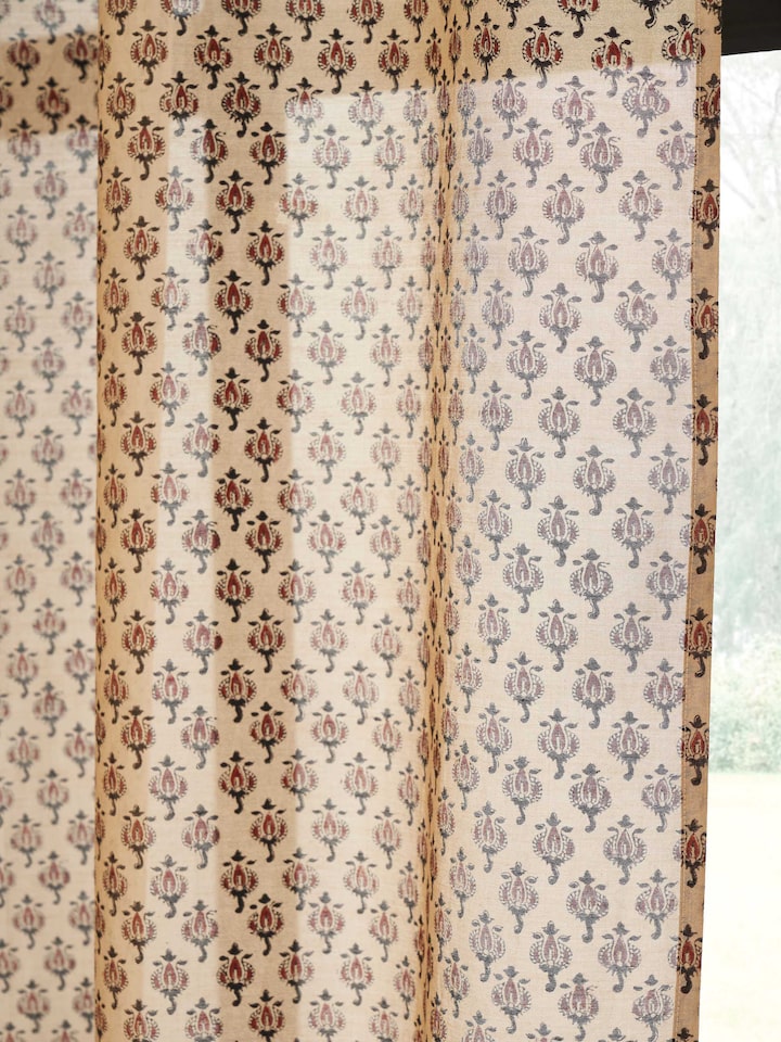 Close-up of traditional Bagru block printed buti on rust sheer curtain.